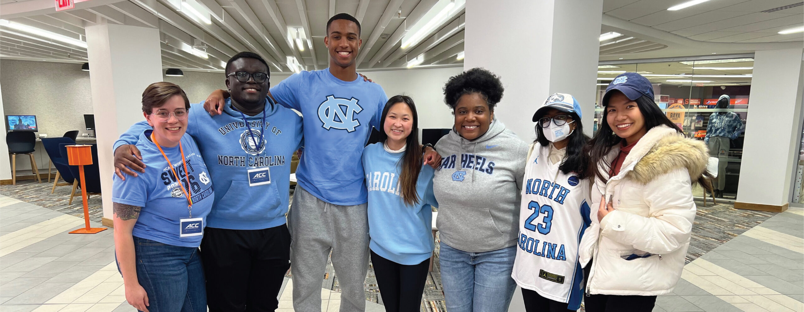 A group of students and their advisor at the ACC Leadership Symposium wearing UNC gear.