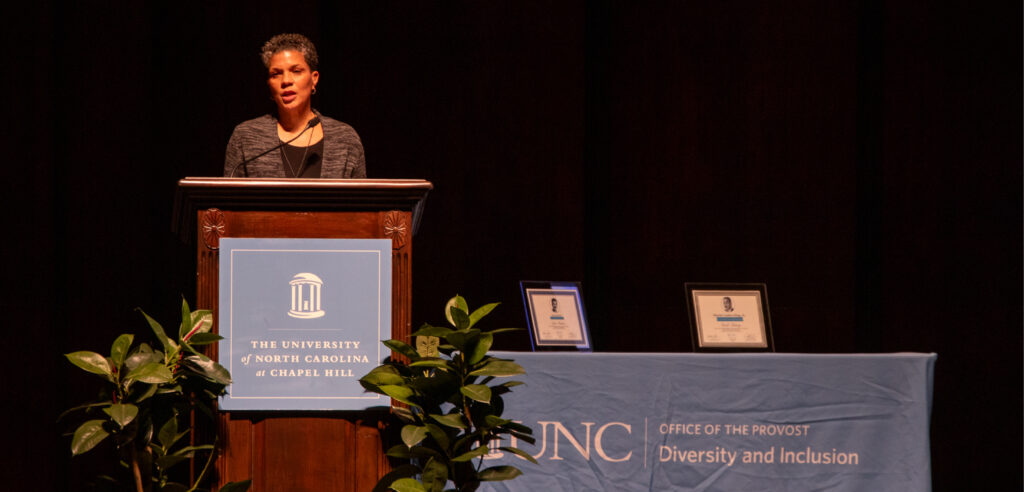 MLK Keynote speaker Michelle Alexander stands at a podium while addressing the crowd.