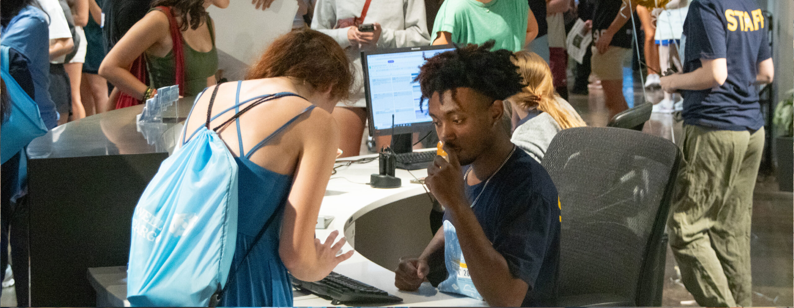 CU student employee assisting another student at the Welcome Desk during FallFest.