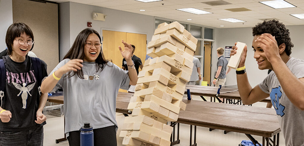 UNC students playing a game of Jenga in a meeting room in the Carolina Union.