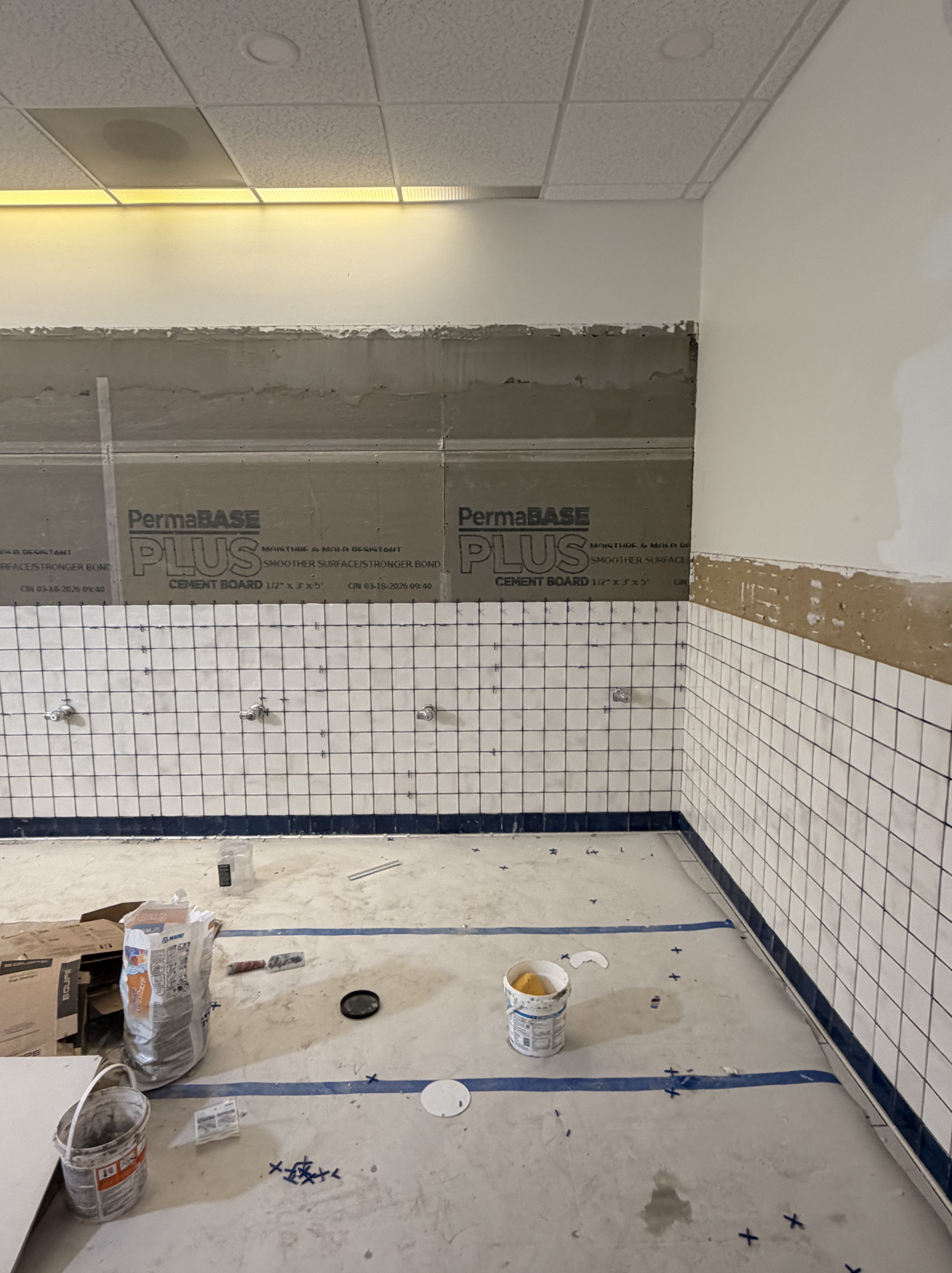 Lower wall tiles completed in the West Lounge bathrooms.