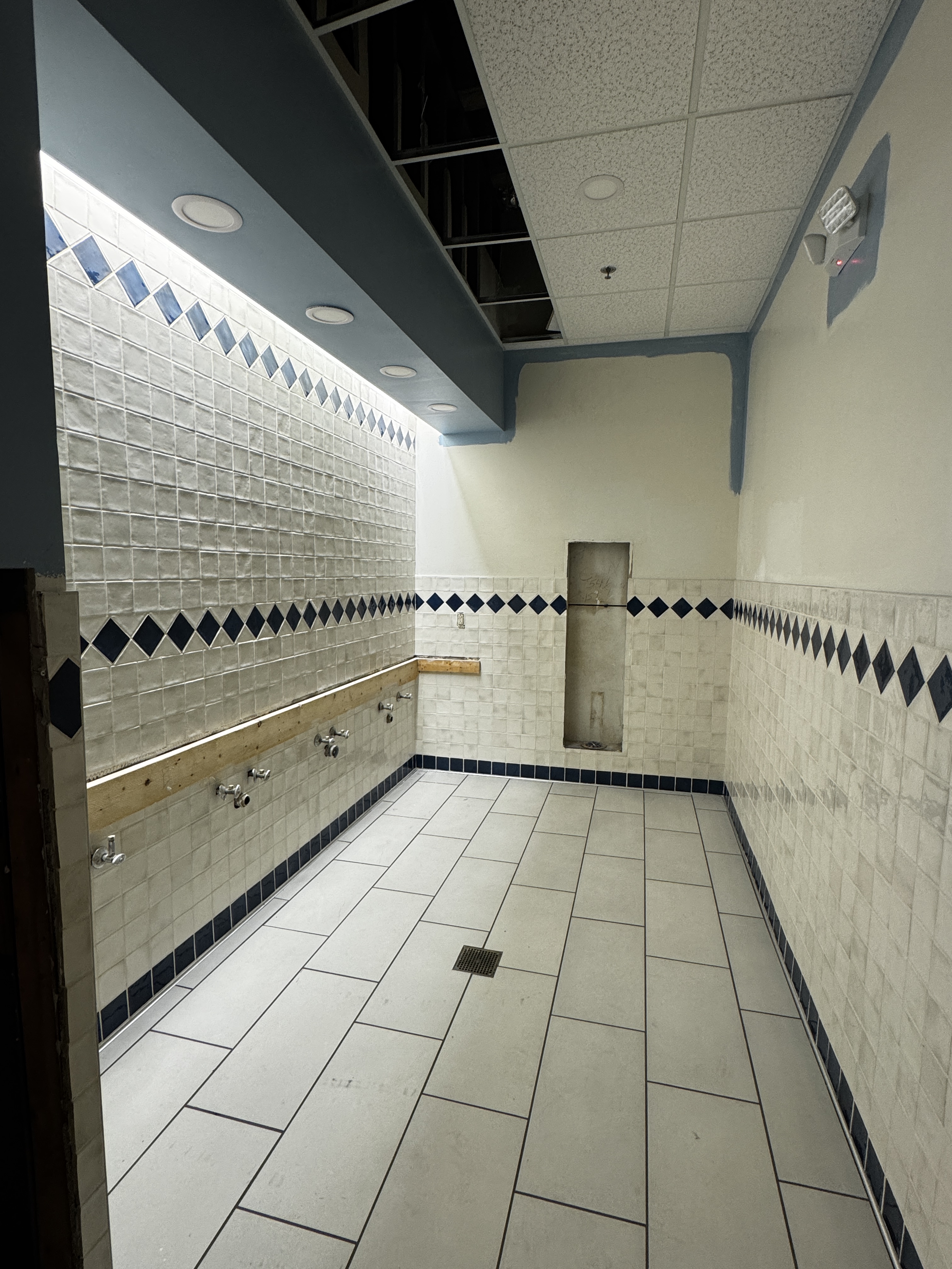 Completed floor and wall tile in the West Lounge bathroom.