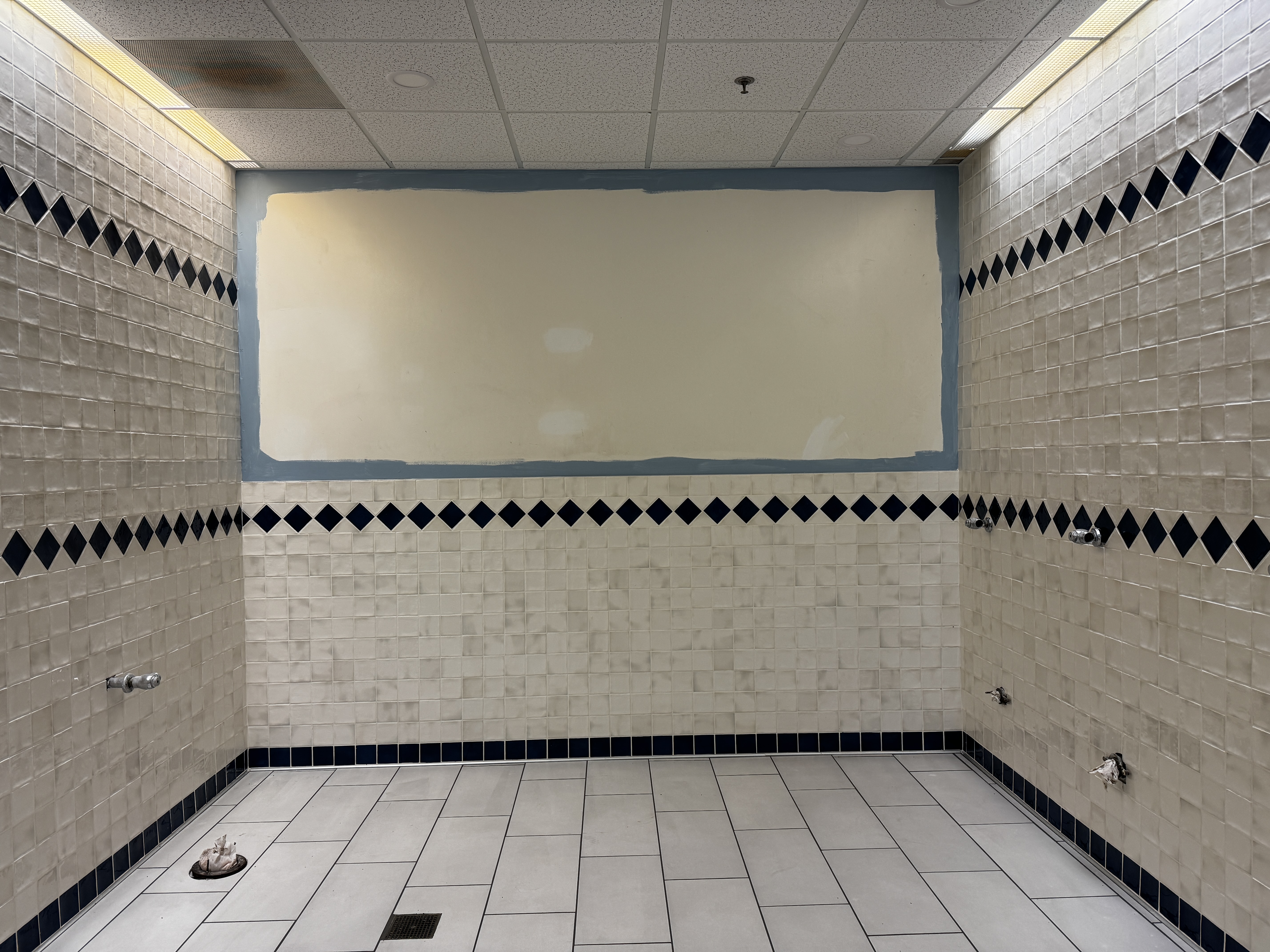Completed floor and wall tile in the West Lounge bathroom.